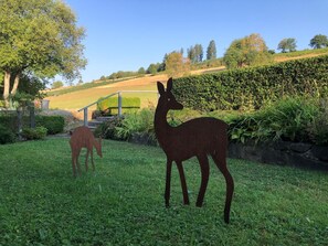 A garden with two deer sculptures, a stone wall, and a grassy area with a staircase leading up. - 120 square meters in a beautiful country house, near hiking and biking trails, close to a golf course (Schmallenberg-Gleidorf)