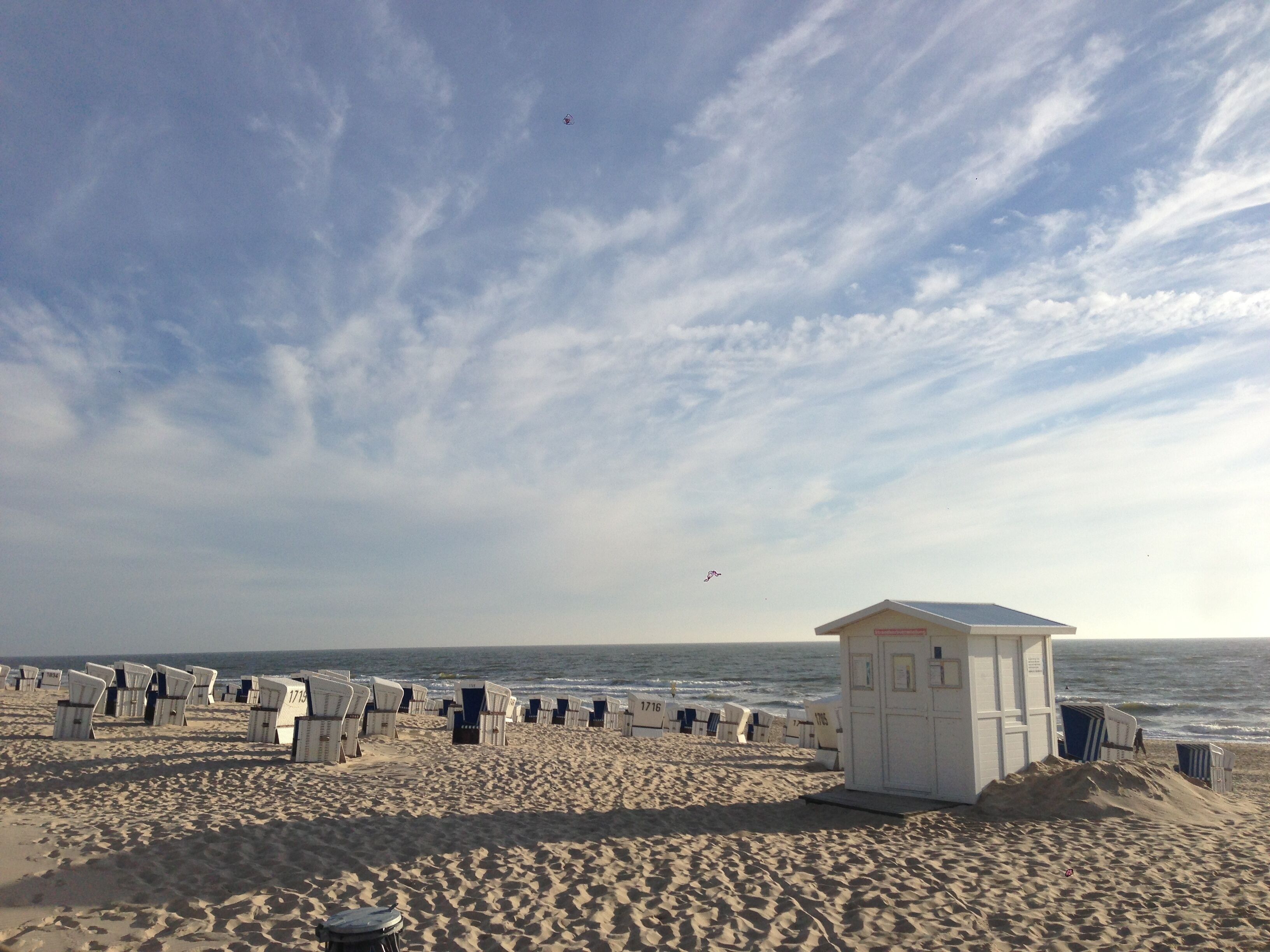 A beach with rows of beach chairs and a lifeguard hut.