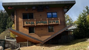 A wooden house with a unique sloped roof design and a balcony with a sign that reads "Motel". - Newly renovated apartment f. d. high standards in an idyllic secluded location (Zachenberg)