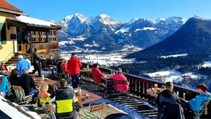 Ein Restaurant mit Blick auf die Berge und Außenbereich, das einen Ausblick auf schneebedeckte Gipfel bietet.