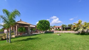 A residential property with a well-maintained lawn, a stone wall, and a tiled-roof structure. - Beautiful detached and family friendly villa with private pool. (Solarino)