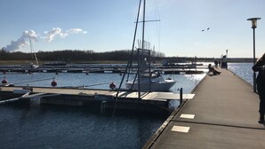 Un port de plaisance avec des bateaux amarrés, une jetée et un ciel dégagé.