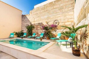 A swimming pool with lounge chairs and potted plants. - Can Caragol (Sineu)