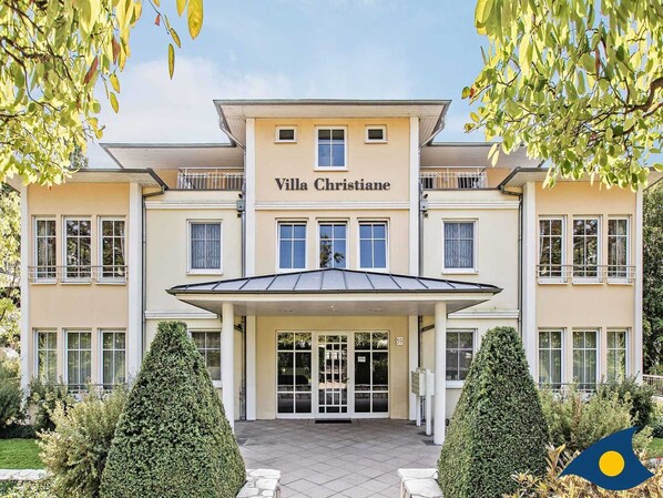 A two-story building named Villa Christiane with a covered entrance, symmetrical windows, and a well-maintained garden. - Villas at Goethe Park, Villa Christiane, Whg. 04 - Lena - Villas at Goethe Park, Villa Christiane, Whg. 04 - Lena (Heringsdorf)