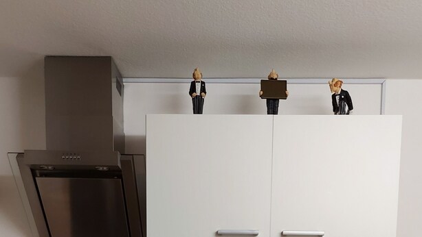 A modern kitchen with white cabinets, a stainless steel sink, a dishwasher, and a stove.
