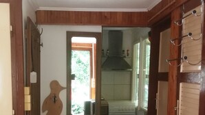 A compact kitchen with wooden cabinets, a built-in oven, and a small window.