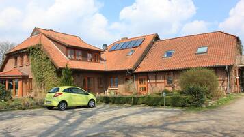 Ein zweistöckiges Haus mit geneigtem Dach, Solaranlagen und einem geparkten Auto in der Auffahrt.