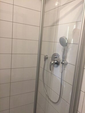 Chuveiro, secador de cabelo, toalhas de banho, papel higiênico