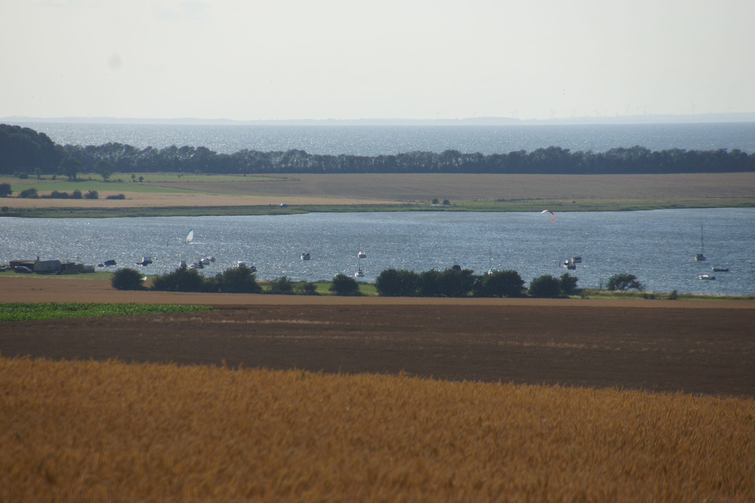 A coastal landscape with fields and water.