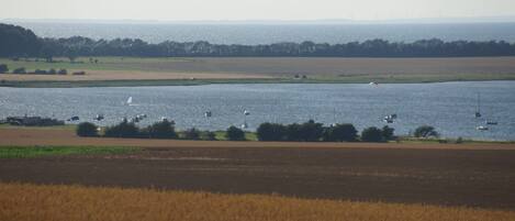 A coastal landscape with fields and water.