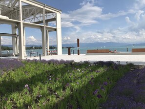 A modern architectural structure with a view of a lake and mountains in the background.