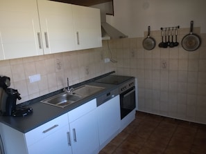 Enjoy cooking in this well-equipped kitchen with an oven, stainless steel sink, and ample storage.
