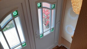 Eine Treppe mit blauen Teppichstufen, die zu einer Tür mit zwei Fenstern führt.