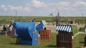 Beach huts with a view of the sea and a flag. - Middle row house near the beach, quiet location but in the middle of life (Butjadingen)