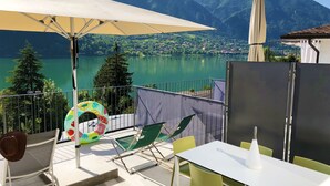 A balcony with a table, chairs, an umbrella, and a colorful inflatable ring. - Directly from the owner (Tre Capitelli)