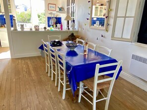 Zona de dinar amb estovell blau, caires blancs i una finestra amb rajoles blaves.