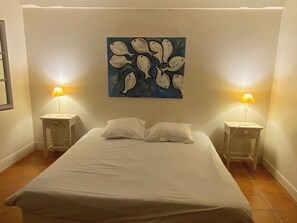 Habitació d'hotel amb un llit, dues taules de nit i un quadre al mur.