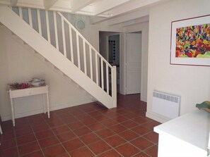 A staircase leading to a second floor, a white console table with decorative items, and a colorful abstract painting on the wall. - Wonderful villa with idyllic garden A0338 (Lège-Cap-Ferret)