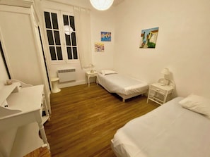 A bedroom with two single beds, a bedside table, a nightstand, a small table with a lamp, and a wall-mounted picture. - Wonderful villa with idyllic garden A0338 (Lège-Cap-Ferret)