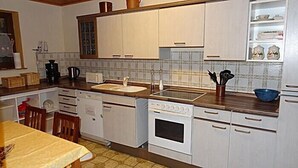 A compact kitchen with white cabinets, a sink, a stove, and a dishwasher. - Large, comfortable apartment in a quiet outskirts. (Sinsheim)