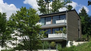 A modern two-story building with large windows and balconies, surrounded by trees and greenery. - FeWo Betz Bodensee in Überlingen (Überlingen)