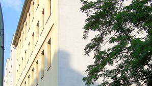 A building with a light facade, a bicycle sign, and a gated entrance. - Renovated old apartment with shower room, separate eat-in kitchen and washing machine (Berlin)