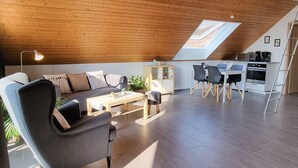 Un loft moderno con tetto spiovente, zona pranzo e cucina.
