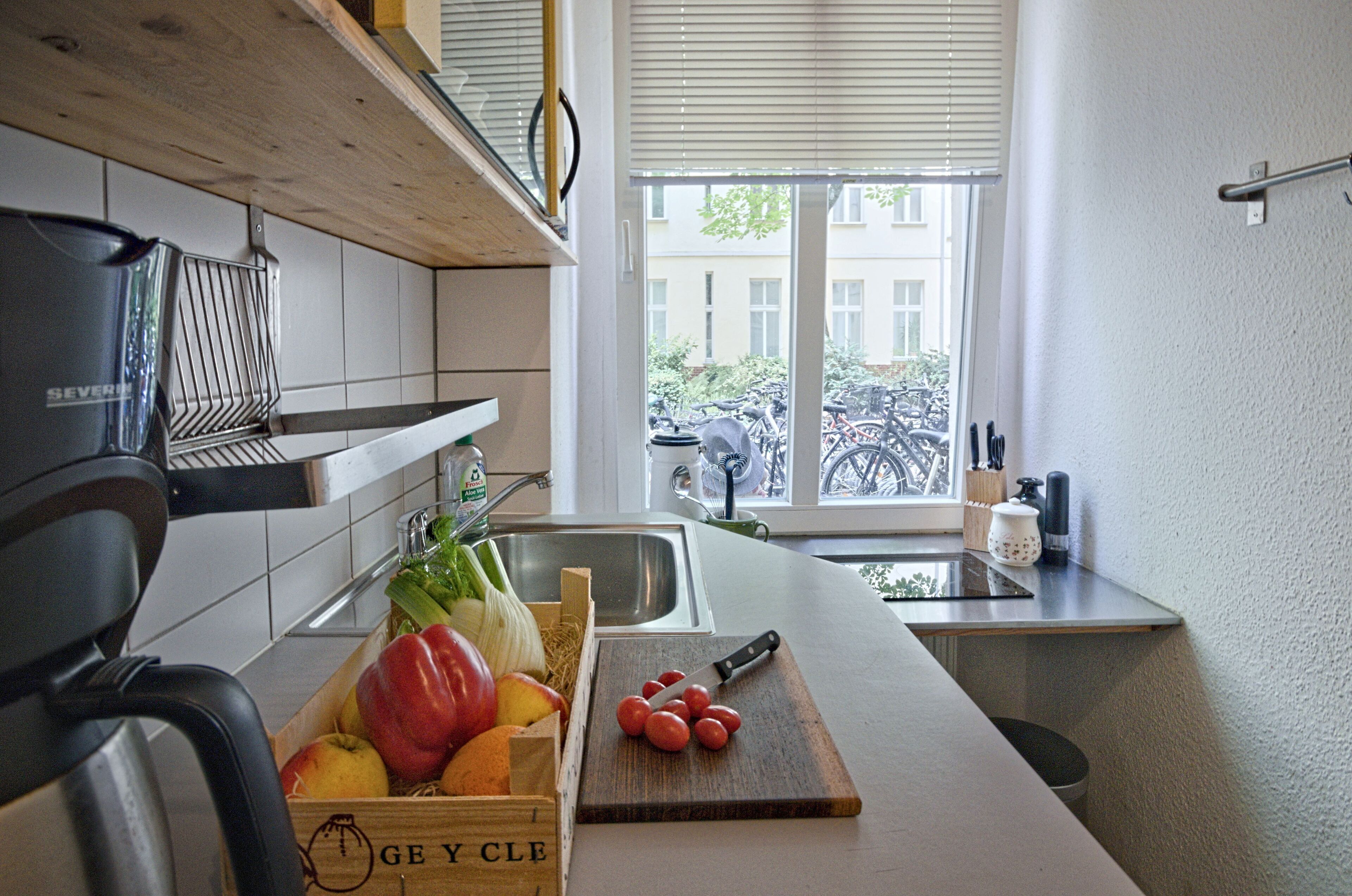 Eine Küche mit einer Holz Arbeitsplatte, einem Spülbecken und einem Fenster mit Blick auf Fahrräder draußen.