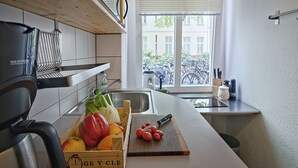 Een keuken met een houten aanrecht, een spoelbak en een raam met uitzicht op fietsen.