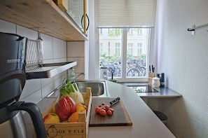 Una cocina con encimera de madera, un lavamanos y una ventana que da a bicicletas en el exterior.
