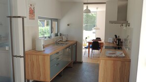 Una cocina moderna con armarios de madera, una isla central y un comedor con mesa y sillas.