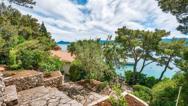 A stone pathway leading to a terrace overlooking a coastal area with trees and a view of the sea. - Nice villa direct on sea,surrounded with lot of mediterranean plants,two minutwe (Klek)