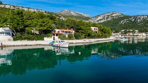 A coastal scene with a marina, boats, and buildings with balconies overlooking the water. - Nice villa direct on sea,surrounded with lot of mediterranean plants,two minutwe (Klek)