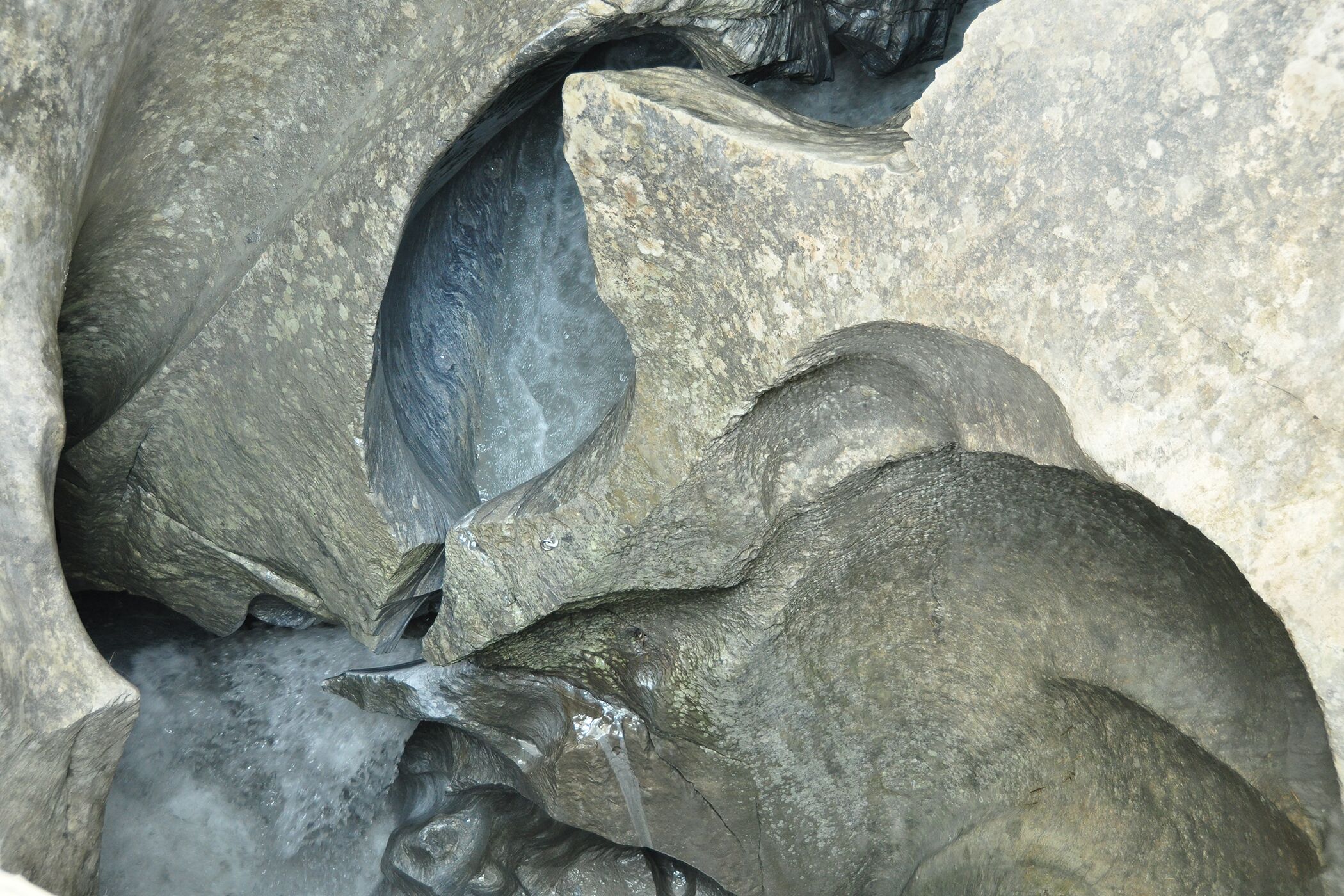 A close-up of a rock formation with water flowing through a crevice.
