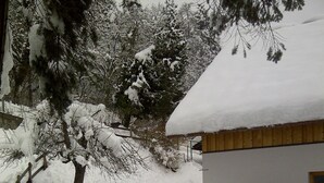 Un paisaje nevado con una casa y un árbol.