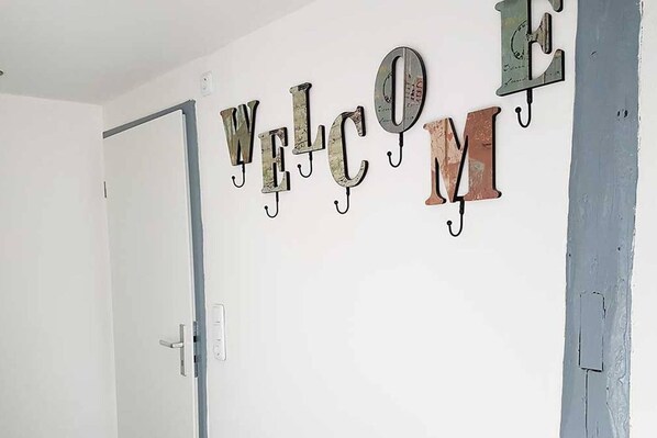 Pared con la palabra "BIENVENIDOS" escrita en letras metálicas con ganchos.