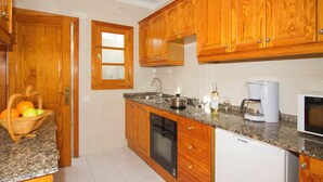A kitchen with wooden cabinets, a granite countertop, a dishwasher, a coffee maker, and a microwave. - Beautiful house with solarheated and private pool (Tias)