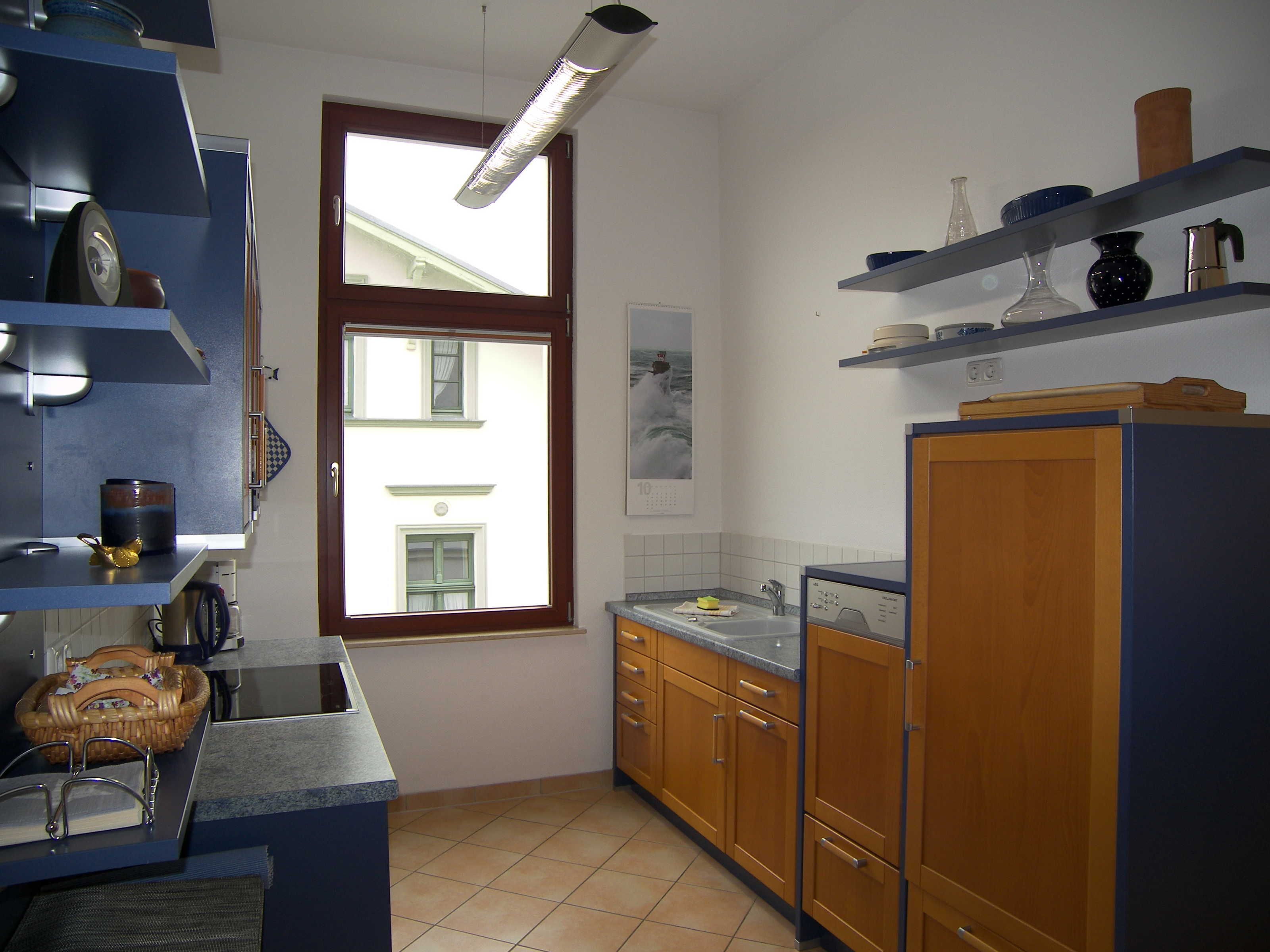 A kitchen with wooden cabinets, a sink, and a window.