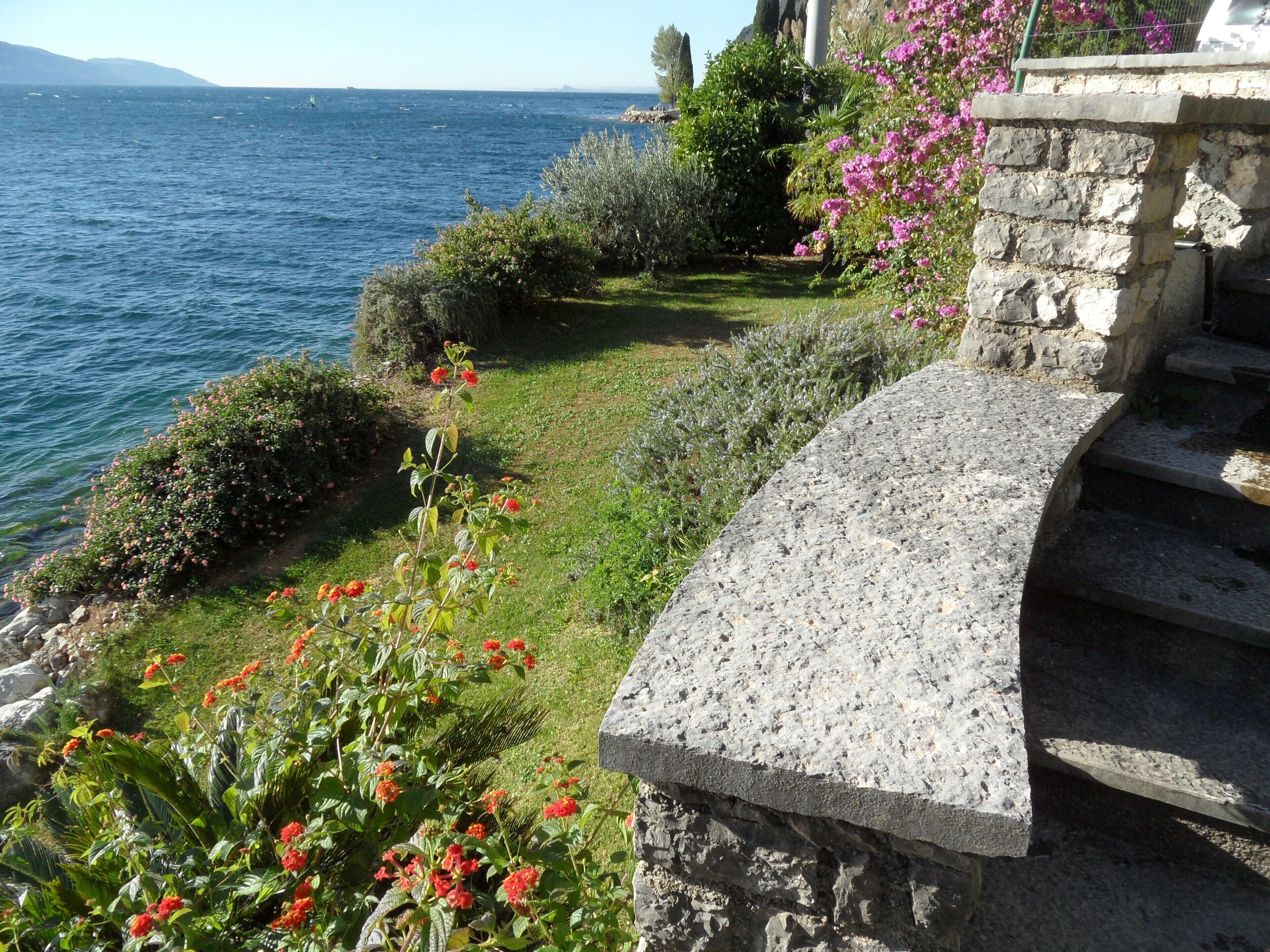 Un jardí costaner amb una escala de pedra que baixa fins a la platja.