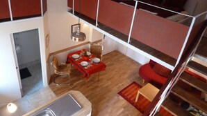 A compact, multi-level apartment with a dining area, a sofa, and a small kitchen. - Central and quiet - a view of the countryside (Berlin)