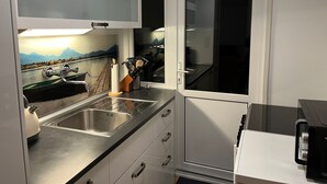 Eine moderne Küche mit Spüle aus Edelstahl, einem Messerblock und Blick auf eine Berglandschaft durch das Fenster.