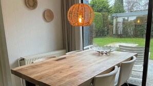 Ein Essbereich mit Holztisch, Metallbeinen und einer Hängeleuchte.