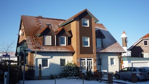 A two-story house with a brick facade, a tiled roof, and a small tower-like structure. - cozy 3-room apartment in Timmendorf-Strand with sea view (Timmendorf-Strand)