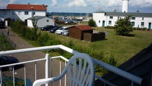 A coastal view with a lighthouse, marina, and residential buildings. - cozy 3-room apartment in Timmendorf-Strand with sea view (Timmendorf-Strand)