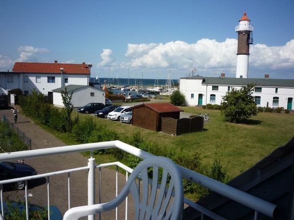 Une vue sur la côte, avec un phare, un port de plaisance et des immeubles résidentiels.