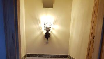 A small, compact bathroom with a toilet, sink, and a wall-mounted light fixture.