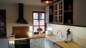 A kitchen with a stove, oven, sink, and cabinets.