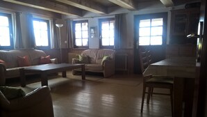 A living room with a sofa, armchairs, a coffee table, and a dining area with a table and chairs. - Former farmhouse in a quiet outskirts. Pets are welcome. (Aichhalden)