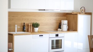 A modern kitchen with white cabinets, a wooden countertop, a built-in oven, and a coffee maker. - New holiday home in the mountains, Bad Mitterndorf, Sonnenalm (Bad Mitterndorf)