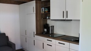 A compact kitchen with white cabinets, a wooden countertop, and a coffee maker. - De Hunk, the small apartment in the town center (Borkum)